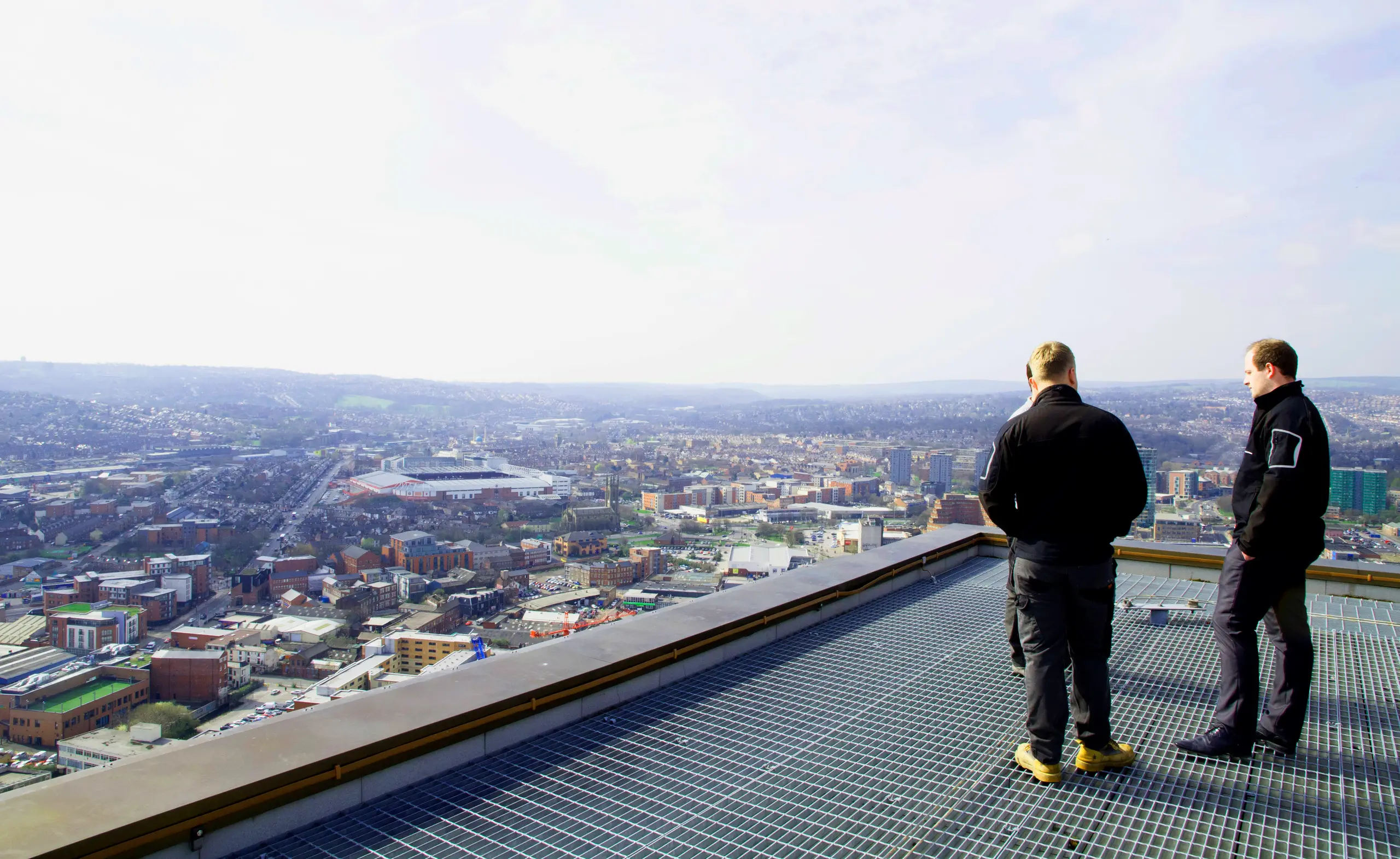 Two EntireFM staff on a rooftop above Sheffield, looking out over the city